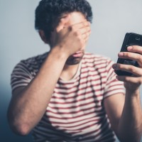 man closed his eyes unable to see mobile screen