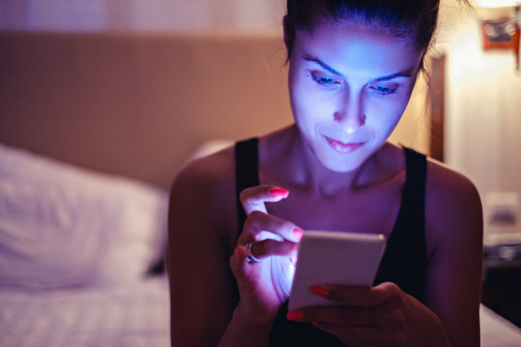 Girl looking at mobile phone in the bedroom