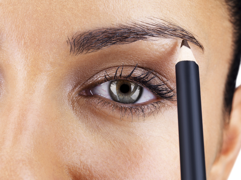 Cropped image of a young female darkening her eyebrows with eyeliner